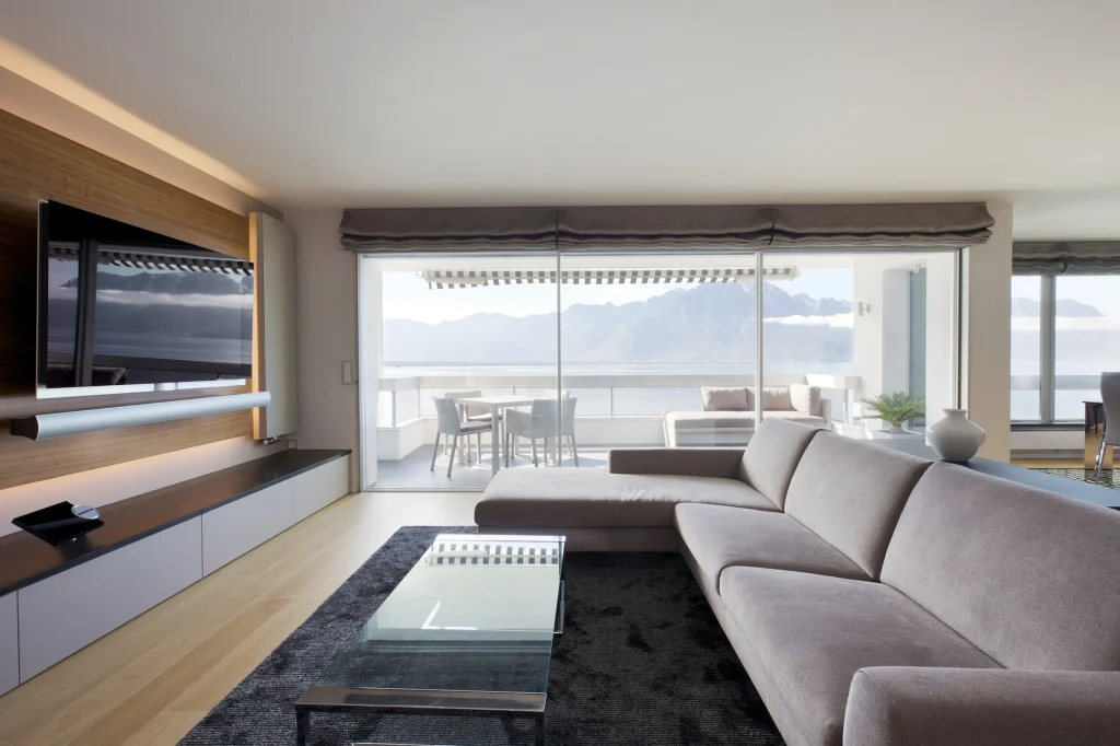 Salon rénové avec grande baie vitrée et vue sur le lac Léman dans un appartement en Suisse