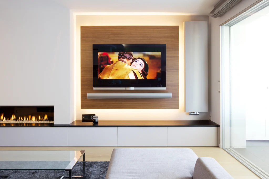 Aménagement TV sur mesure avec menuiserie intégrée dans un appartement rénové en Suisse