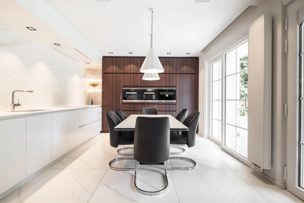 Cuisine équipée avec châssis coulissant sur mesure et matériaux haut de gamme dans une rénovation de villa