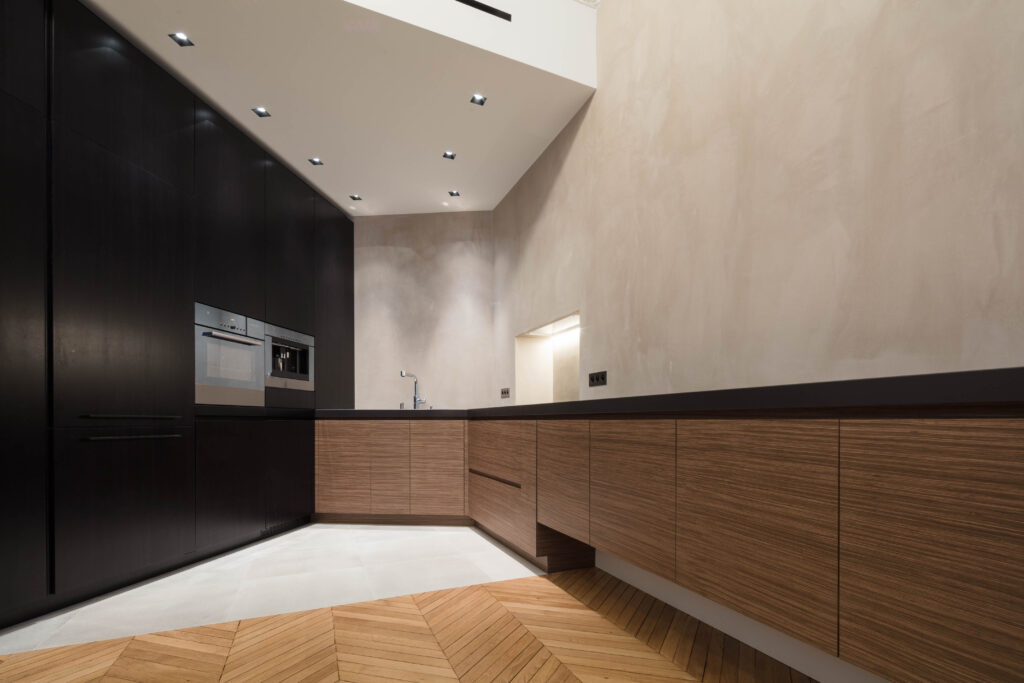 Cuisine rénovée avec placages bois et béton ciré dans un appartement parisien au style contemporain et chaleureux